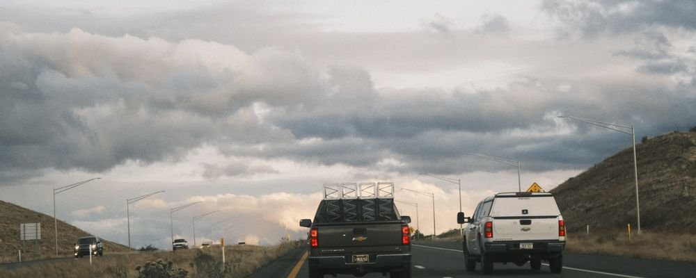 Two pickup trucks on a scenic open highway
